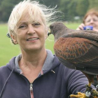 Val, with an falcon perched on her arm (thankfully outside of work)