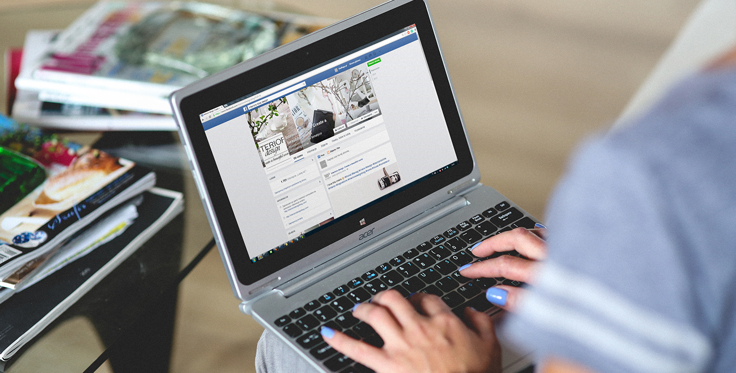 Woman on a laptop with Facebook on the screen